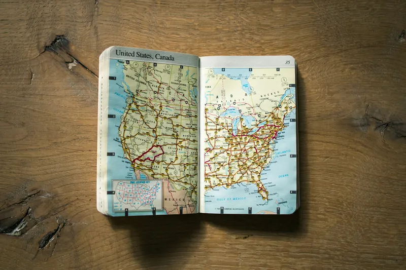 Printed paper map of the United States laid flat on a brown wooden surface