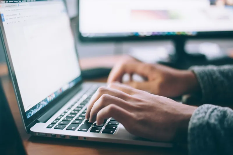 Freelancer reconciling invoices and expenses at a home office desk