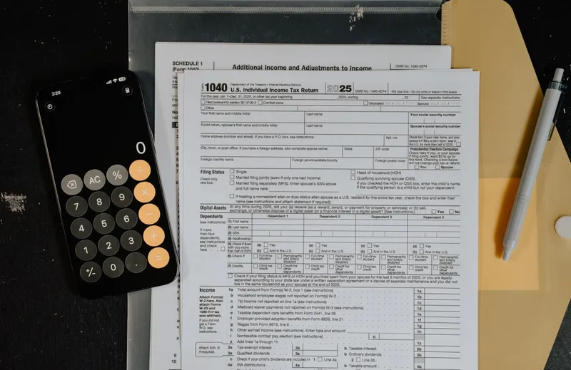 Tax forms and calculator on a desk.